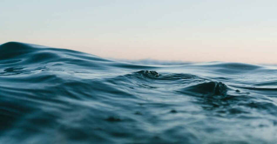 Tranquil ocean waves under a soft sunset sky, perfect for backgrounds.