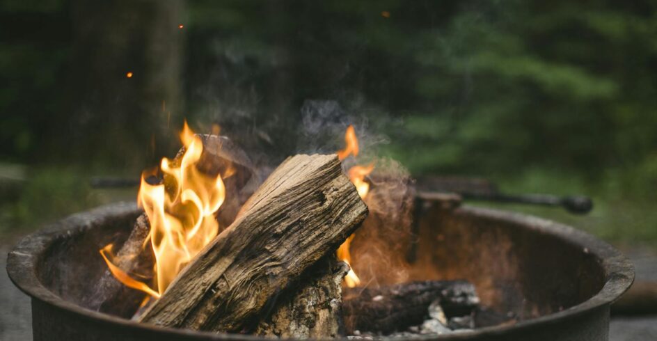 A cozy campfire burning with bright flames in a metal pit, perfect for a night outdoors.