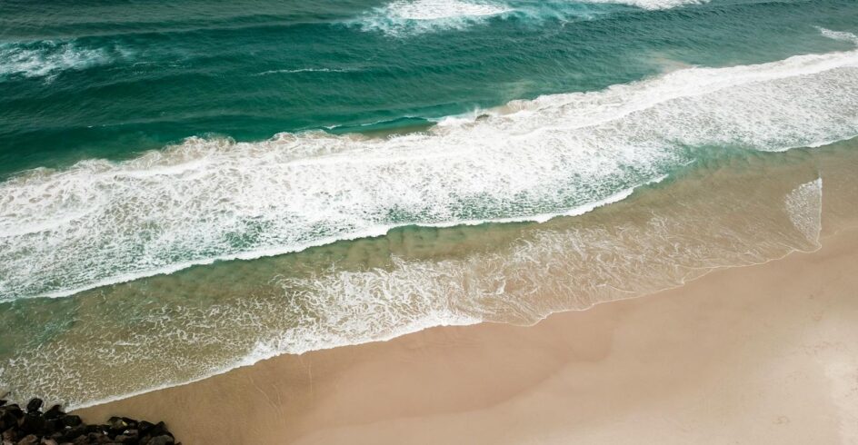A stunning aerial view of waves crashing on Tallebudgera Beach, QLD, Australia.