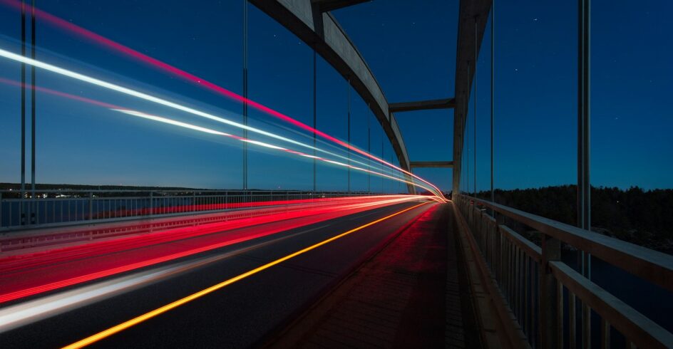 gray suspension bridge with streaks of light time lapse photography