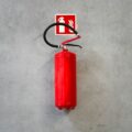 a red fire extinguisher hanging on a wall